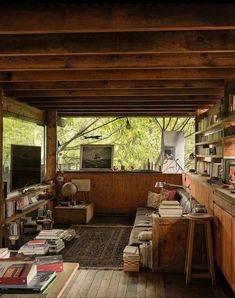 an open living room with lots of books on the floor and shelves full of books