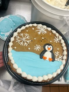 a cake decorated with a penguin and snowflakes