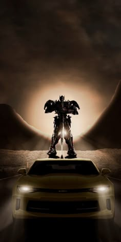 an image of a car in front of a giant robot with wings on it's head