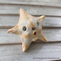 a starfish ornament hanging on the side of a wooden wall with eyes