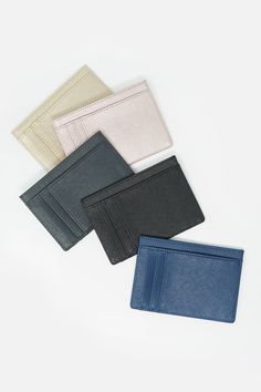 four different colored leather wallets sitting next to each other