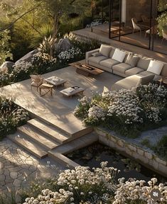 an aerial view of a patio with seating and flowers in the foreground, surrounded by greenery