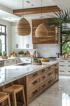 a kitchen filled with lots of counter top space and hanging lights above the island area