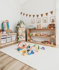 a child's playroom with toys on the floor and shelves in the background