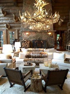 a living room filled with lots of furniture and a chandelier hanging from the ceiling