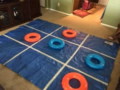 a blue tarp with orange rings on it in the middle of a living room