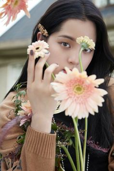 a woman holding flowers in front of her face