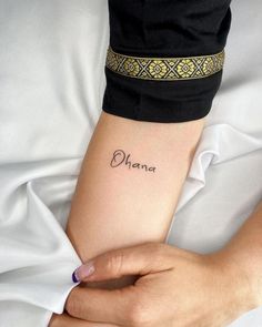 a woman with a tattoo on her arm that says, diamer in cursive font