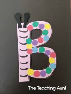 the letter b is made out of paper with polka dots and black scissors on it