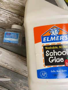 a bottle of school glue sitting on top of a wooden table