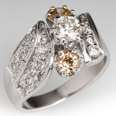 a fancy ring with three stones on the side and two rows of diamonds around it