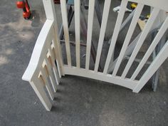 a white wooden bench sitting on top of a cement ground