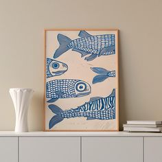 there is a blue and white fish print on the wall next to a book shelf