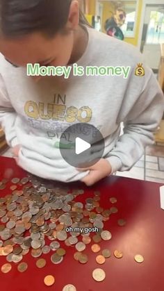 a man is looking at coins on a red table in front of him and the caption reads money is money