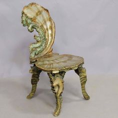 an antique chair with shell like decoration on the back