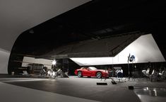 a red sports car parked in front of a camera set up for a photo shoot