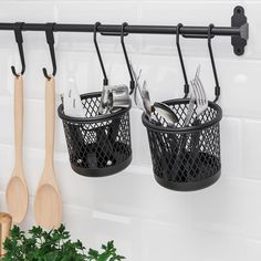 two black baskets with utensils hanging from hooks