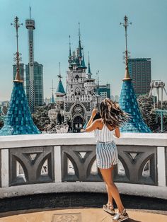 a woman standing on top of a skateboard in front of a castle