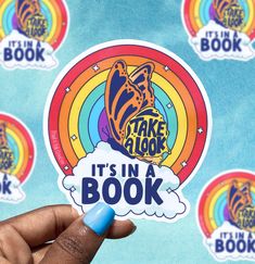 someone holding up a sticker that says take a look it's in a book