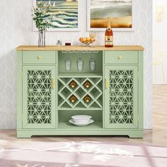 a green cabinet with wine bottles and glasses on it in front of a white wall