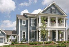 a house with blue siding and white trim on the front, two storyed home