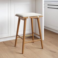 a white counter top sitting next to a wooden stool