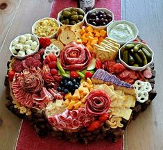 a large platter of meats, cheeses, crackers and olives