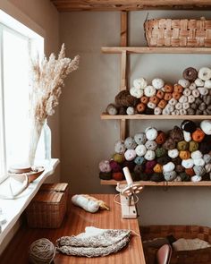 there are many balls of yarn on the shelves