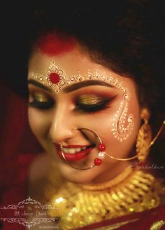 a woman with gold and red makeup on her face