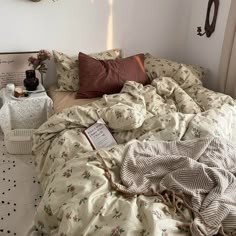 an unmade bed in a bedroom with pillows and blankets on top of the bedspread