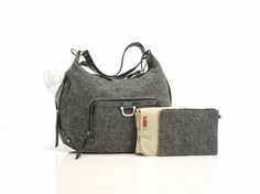 two pieces of gray and black purses on a white surface with one bag in the foreground