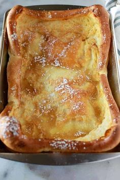 a pan filled with bread covered in powdered sugar