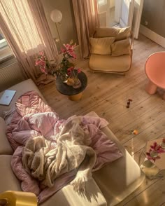 a living room filled with furniture and flowers on top of the floor next to a window