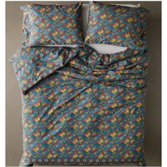 an image of a bed with blue and yellow flowers on the comforter, sheets and pillowcases