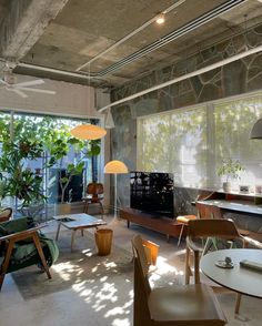 a living room filled with furniture next to a window covered in plants and windowsills