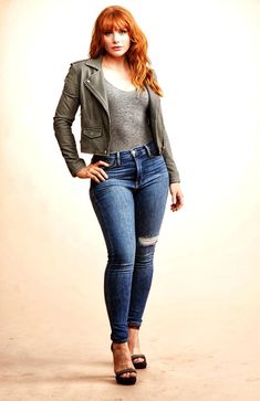 a woman in jeans and jacket posing for the camera