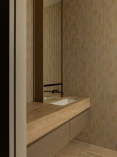 a bathroom with a sink, mirror and tiled wall in it's center area