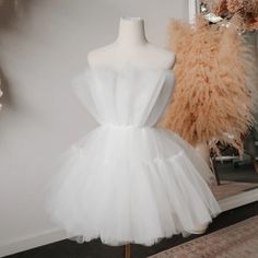 a mannequin is next to a white dress