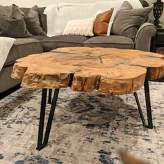 a living room with a couch and table made out of tree trunks on the floor