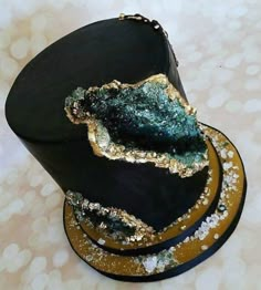 a black hat with gold and green decorations on it