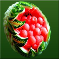 a watermelon with leaves and berries in it's center on a green background