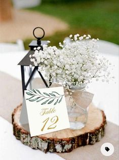 a table number is placed on top of a wooden slice with baby's breath flowers