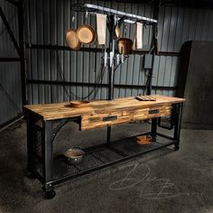 a wooden table sitting in front of a metal rack filled with pots and pans