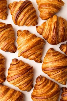 several croissants are arranged on a white surface