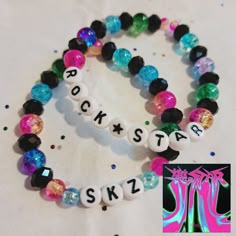 two bracelets that say rock star and sk2l are on a table with confetti