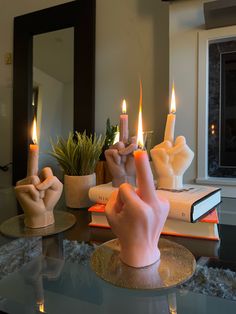 a candle that is on top of a table with two fingers in front of it