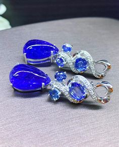 "BRAND-NEW!! ONE OF A KIND, HANDCRAFTED EARRINGS. So Perfect Jewelry proudly presents!! HUGE 2-in-1 PAIR! Delicately handcrafted, HUGE TANZANITE CABOCHON TEARDROP EARRINGS! With 6 pcs of sparkling Cornflower Blue Ceylon Sapphires! Accented with superb quality, natural diamonds, set in handcrafted 18K solid white gold earrings. These earrings will gain you some serious compliments and attentions! So vivid! WITH VIVID PURPLISH BLUE TANZANITE, so gorgeous! Classy and ONE-OF-A-KIND, elegant and HUGE Violet Cocktail, Ceylon Blue Sapphire, Earrings Dangling, Sapphire Color, Blue Tanzanite, Vs Diamond, White Gold Earrings, White Gold Engagement Rings, Handcrafted Earrings