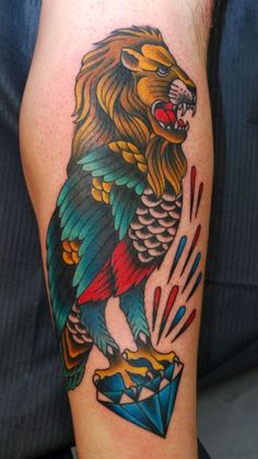 a man with a colorful tattoo on his arm holding a diamond and a lion's head