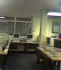 an office cubicle with multiple computers and desks