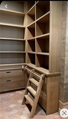 an empty room with wooden shelves and stairs